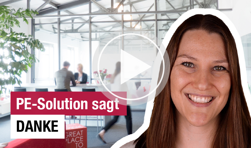 Ein Video-Thumbnail zeigt eine lächelnde Frau mit braunen Haaren im Vordergrund, rechts im Bild. Im Hintergrund befindet sich ein modernes Büro mit Glaswänden und mehreren Personen, die an einem Tisch sitzen. Ein Play-Symbol über dem Hintergrund signalisiert, dass es sich um ein Video handelt. Der Text 'PE-Solution sagt DANKE' ist in Weiß und Rot auf dem Bild platziert.
