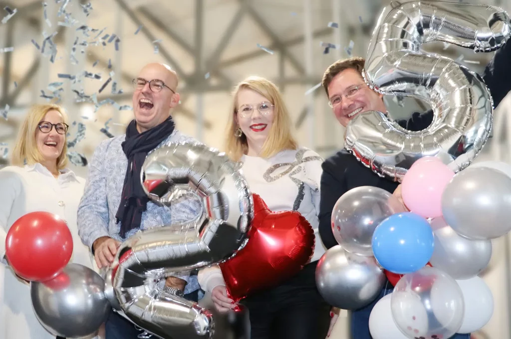 PE Solution feiert 25-jähriges Jubiläum: Ein starkes Team, sichtbare Freude und ein besonderes Unternehmens-Highlight. Das Bild zeigt Mitarbeitende von PE Solution bei der Jubiläumsfeier mit Konfetti, Luftballons und der silbernen ‚25‘ – ein Moment, der Teamgeist, Erfolg und Zusammenhalt symbolisiert.